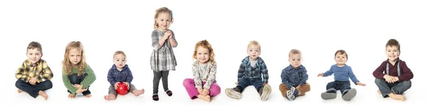 Группа детей и детей, сидящих на белом фоне студии — стоковое фото