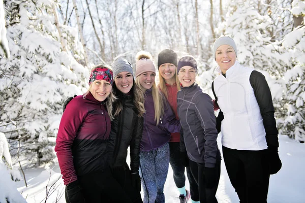 Grupo de amigos disfrutando trotando en la nieve en invierno —  Fotos de Stock