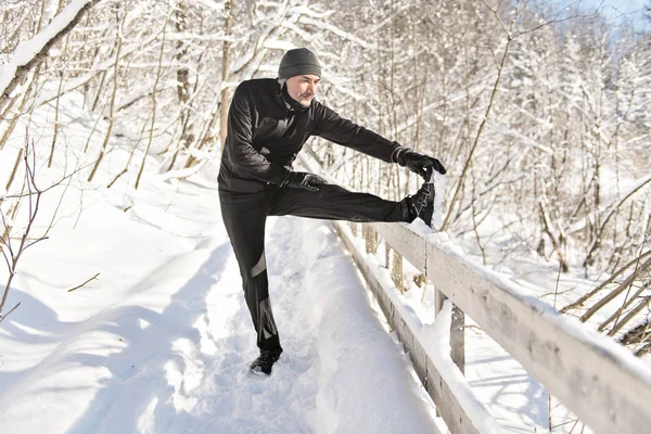 Stretching hó erdő, bautiful napos téli napon az ember — Stock Fotó