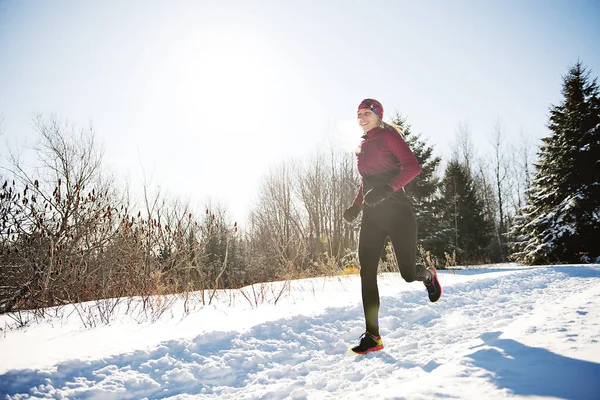 Милая женщина бежит в снежном парке — стоковое фото