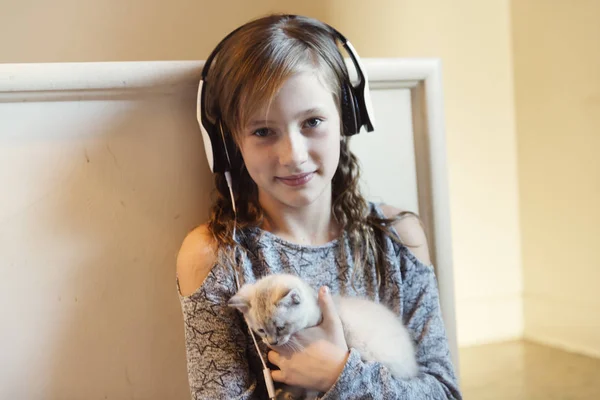 子猫と 10 歳の少女は自宅ヘッドフォンを着用 — ストック写真
