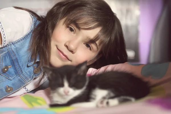 7 anni ragazza con gattino a casa letto — Foto Stock