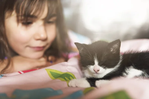 7-jähriges Mädchen mit Kätzchen im heimischen Bett — Stockfoto