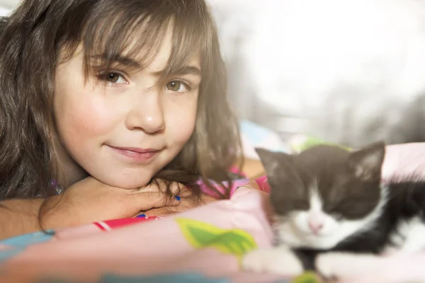 7 ans fille avec chaton à la maison lit — Photo