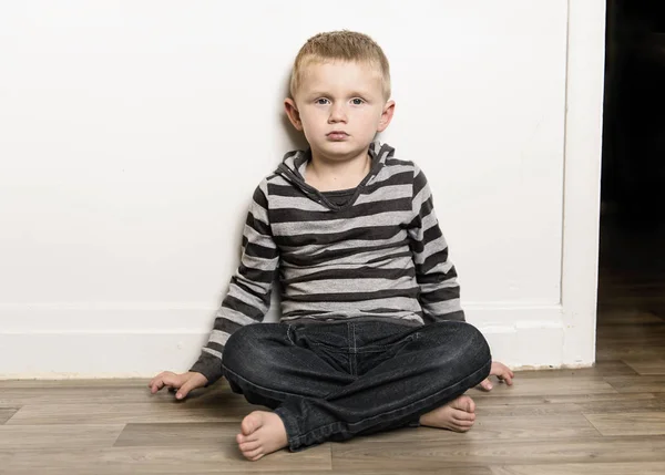 Niño pequeño se sienta en el suelo en casa — Foto de Stock