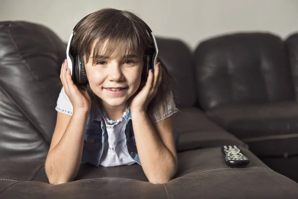 ソファーで音楽を聞くこと 7 歳の女の子 — ストック写真