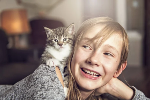 Preteen dziewczyna 10 lat z jej kot pet na kanapie — Zdjęcie stockowe