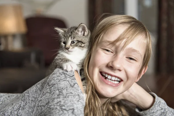 10-jähriges Mädchen mit ihrem Katzenhaustier auf dem Sofa — Stockfoto