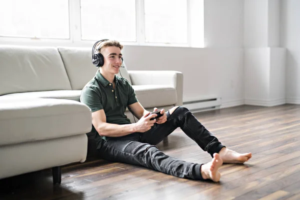 Ung attraktiv man spela TV-spel i vardagsrummet — Stockfoto
