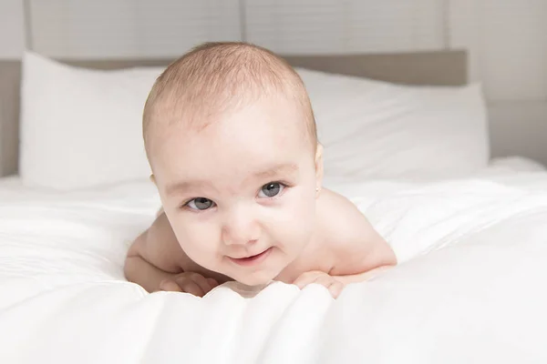 Cute little baby on the white bed — Stock Photo, Image