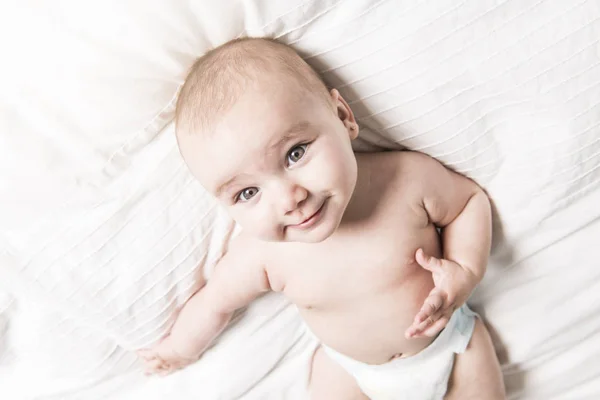白いベッドにかわいい赤ちゃん — ストック写真