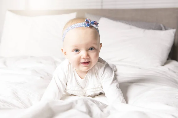 Hermoso bebé en ropa de cama blanca con ojo azul —  Fotos de Stock