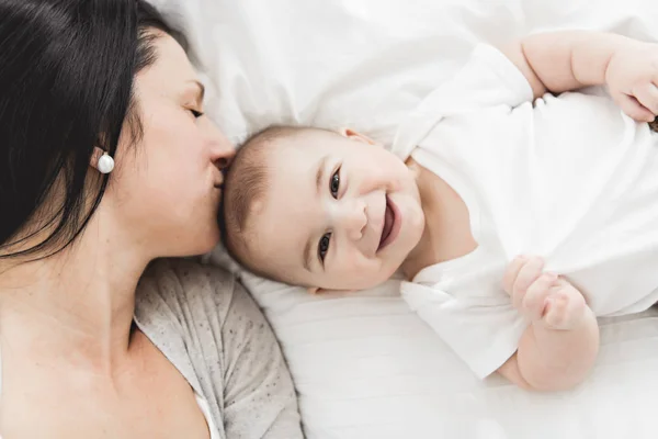 Mother with a baby on bed at home — Stock Photo, Image