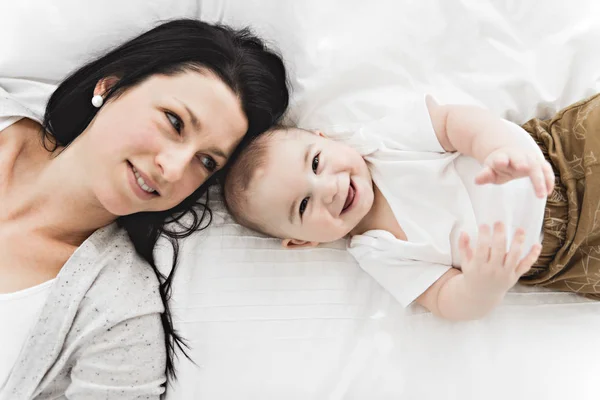 Madre con un bambino sul letto a casa — Foto Stock