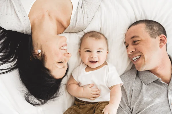 Preciosa familia feliz en el dormitorio, disparado desde arriba — Foto de Stock