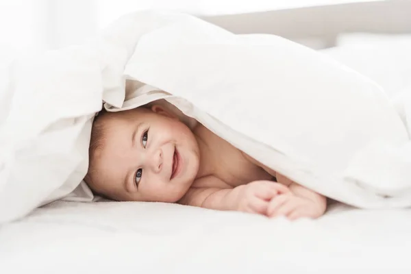 Ritratto di un bambino sul letto in camera da letto — Foto Stock