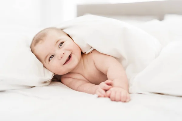 Retrato de un niño en la cama en el dormitorio — Foto de Stock