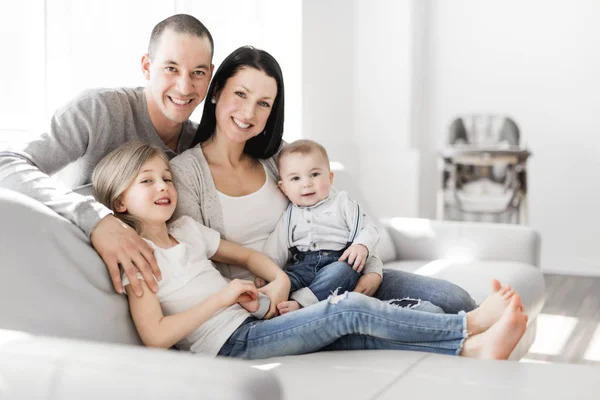 Familia joven en casa divirtiéndose en el sofá — Foto de Stock