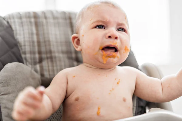 El bebé sucio y sucio está comiendo bocadillos y llorando. . — Foto de Stock