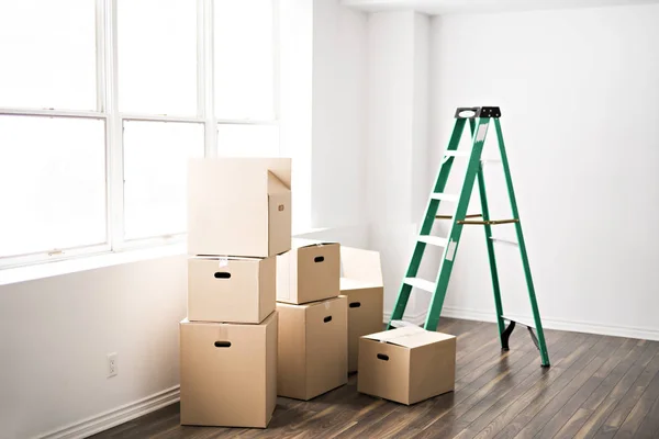 Heleboel doos thuis met venster op rug en ladder — Stockfoto