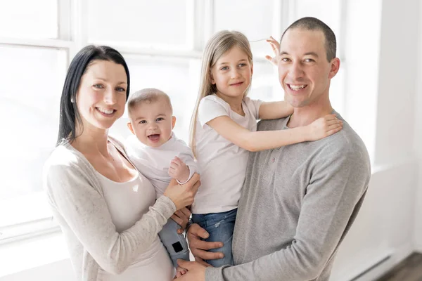 Famille de quatre personnes sur une belle chambre avec fenêtre blanche — Photo