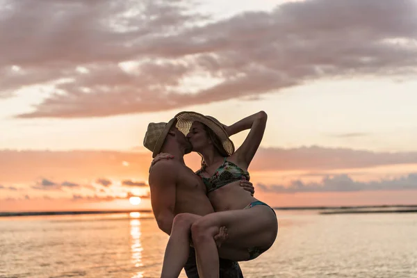 Ζευγάρι στην αγάπη, έχοντας ρομαντικά τρυφερές στιγμές στο ηλιοβασίλεμα στην παραλία — Φωτογραφία Αρχείου