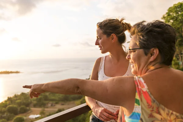 Mutter und Tochter bei Sonnenuntergang, Frau zeigt auf etwas — Stockfoto