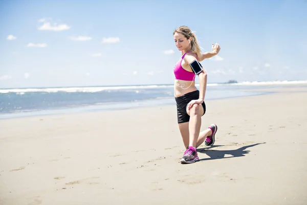 Mujer joven corriendo en la playa en el día de verano. Corredor atleta haciendo ejercicio activamente en el día soleado —  Fotos de Stock