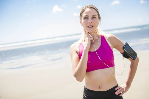 Mujer joven corriendo en la playa en el día de verano. Corredor atleta haciendo ejercicio activamente en el día soleado —  Fotos de Stock