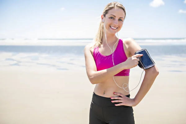 Jonge vrouw joggen op het strand in zomerdag. Atleet runner actief uitoefenen in zonnige dag — Stockfoto