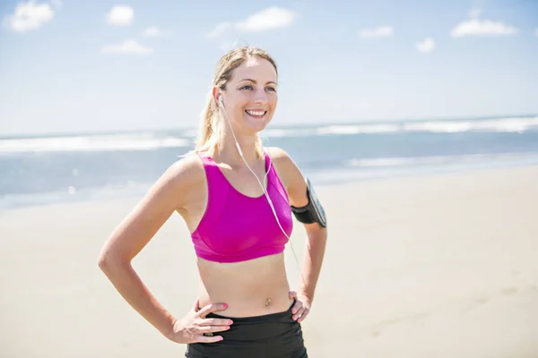 Mujer joven corriendo en la playa en el día de verano. Corredor atleta haciendo ejercicio activamente en el día soleado —  Fotos de Stock