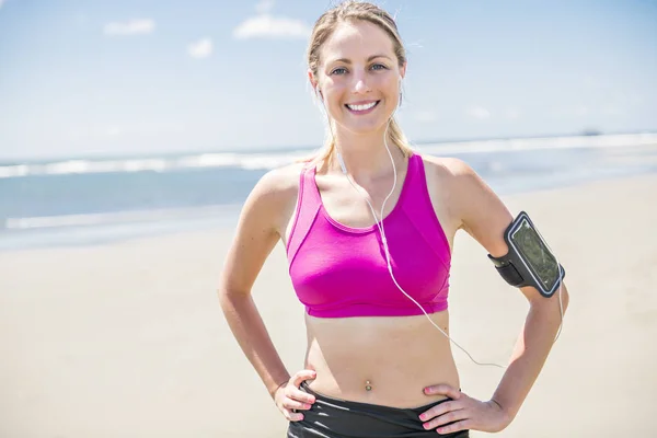 Mujer joven corriendo en la playa en el día de verano. Corredor atleta haciendo ejercicio activamente en el día soleado —  Fotos de Stock