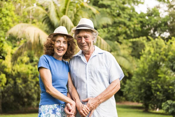 Portrait of a beautiful elderly couple standing embracing outdoors — Stock Photo, Image
