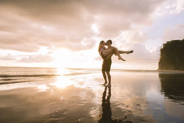 Paar verliefd met romantische tedere momenten bij zonsondergang op het strand — Stockfoto