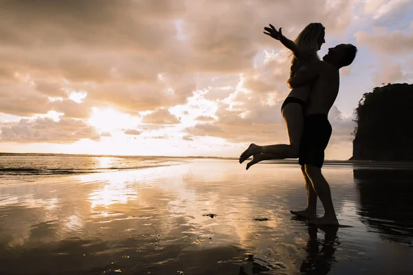 Paar verliefd met romantische tedere momenten bij zonsondergang op het strand — Stockfoto