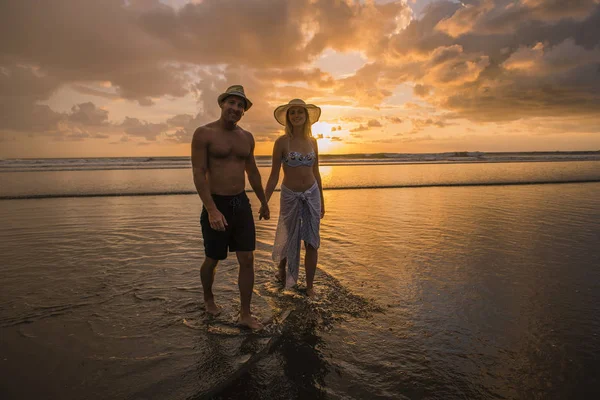 Ζευγάρι στην αγάπη, έχοντας ρομαντικά τρυφερές στιγμές στο ηλιοβασίλεμα στην παραλία — Φωτογραφία Αρχείου