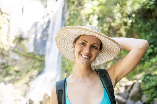 Attractive woman standing by waterfalls on his back — Stock Photo, Image