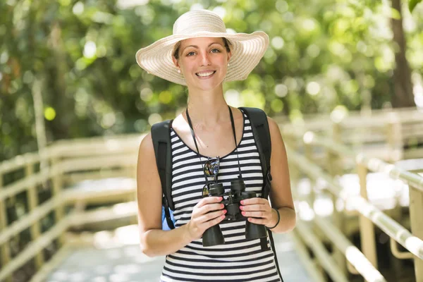 Touristin mit Fernglas sucht im Wald nach etwas — Stockfoto