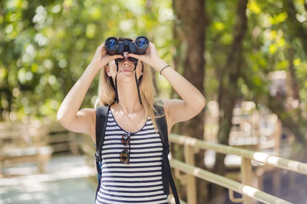 Touristin mit Fernglas sucht im Wald nach etwas — Stockfoto