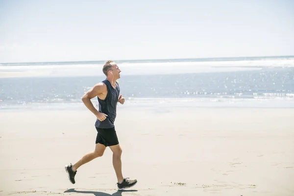 Egy férfi, jogging a nap idő, a strandon — Stock Fotó