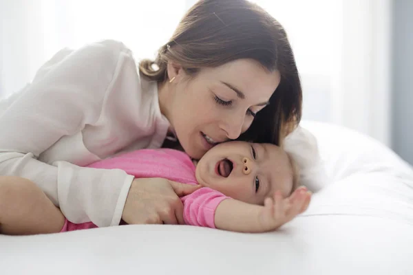 Madre e hijo en una cama blanca . — Foto de Stock