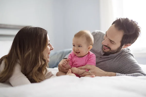 Madre padre e hijo bebé en una cama blanca. — Foto de Stock