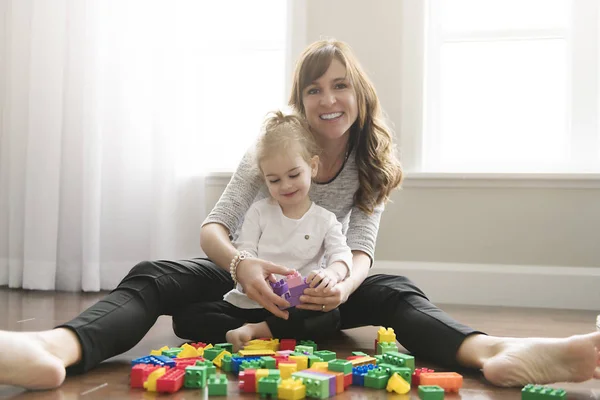 Madre e hija construyendo desde bloques de juguetes en casa — Foto de Stock