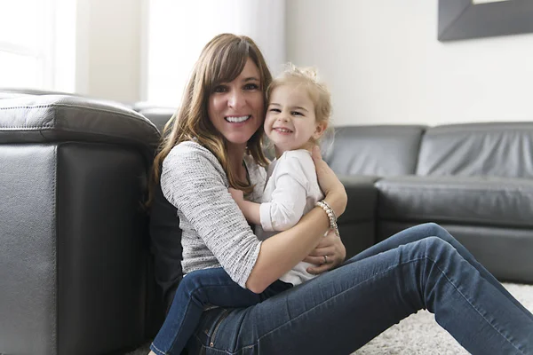 Gelukkig moeder met haar dochter in de huiskamer — Stockfoto