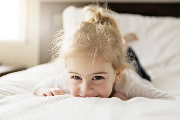 Jeune fille de deux ans se détendre au lit, sentiments positifs — Photo