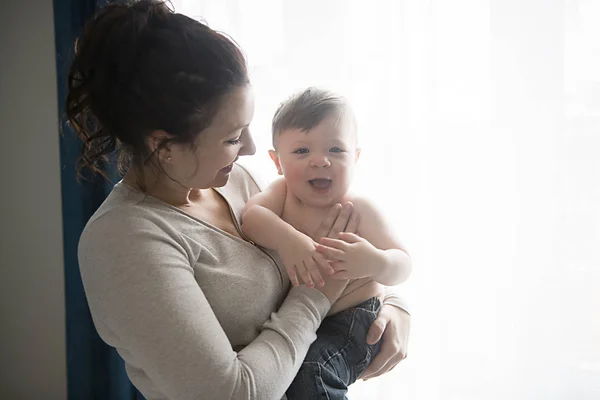 Madre con hijos cerca de la ventana — Foto de Stock