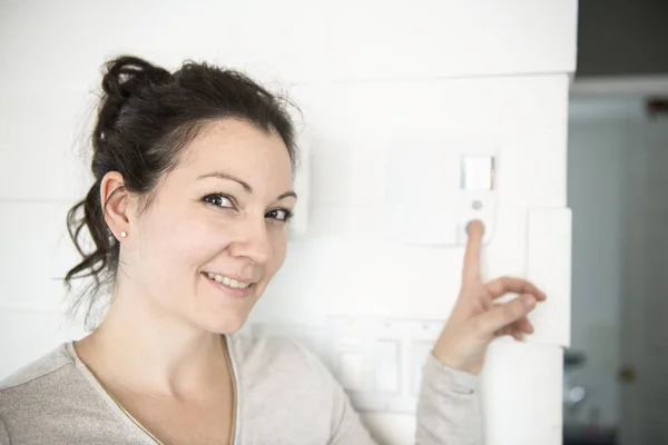 Uma mulher agradável definir o termostato em casa . — Fotografia de Stock