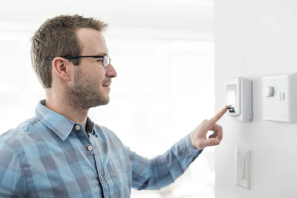 Ein netter Mann stellte das Thermostat am Haus ein. — Stockfoto