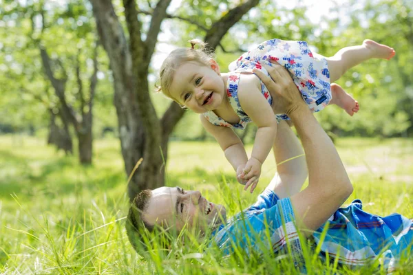 Um pai com seu bebê ao ar livre no parque — Fotografia de Stock