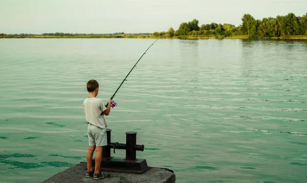 Niño pescando en la orilla del río — Foto de Stock